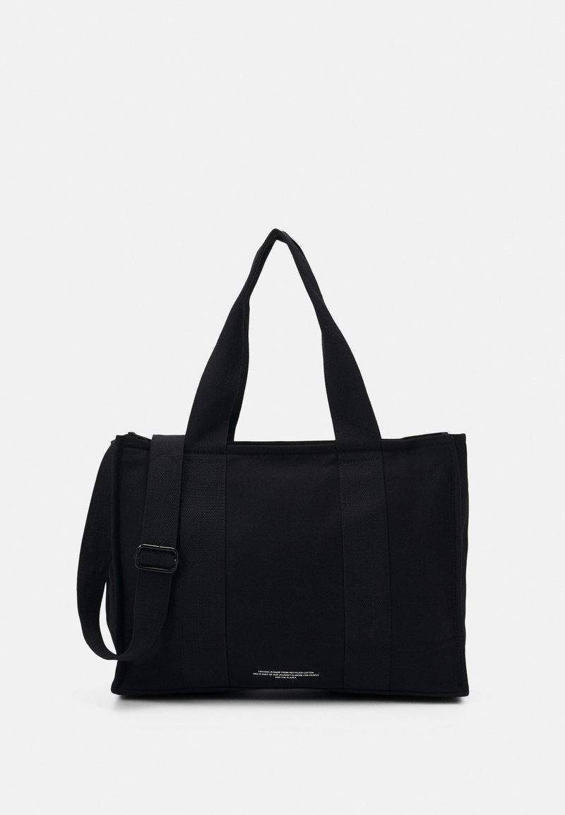 Svart tote-bag laget av slitesterkt stoff. Har to korte håndtak og et langt justerbart stropp. Rektangulær form med minimalistisk design.