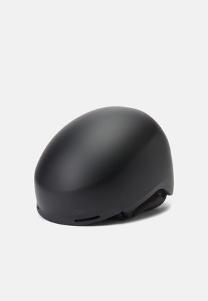 Casque noir mat avec un design lisse et arrondi et des ouvertures de ventilation subtiles. Offre un ajustement sécurisé et un logo minimaliste.