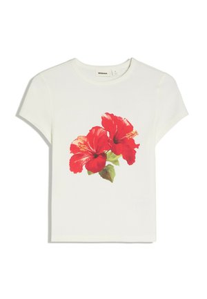 T-shirt blanc manches courtes avec col rond, orné de deux grandes fleurs d’hibiscus rouges avec des feuilles vertes imprimées à l’avant.