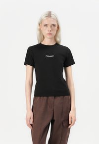 T-shirt preta de algodão com mangas curtas e gola redonda, com o logótipo "PEGADOR" impresso em branco na frente.