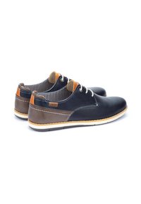Scarpe da uomo stringate in pelle blu navy con accenti marroni. Caratterizzate da lacci bianchi, interno a righe e suola testurizzata per una maggiore aderenza.