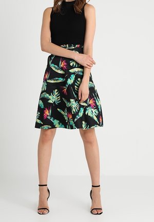 Falda negra con un vibrante estampado tropical que presenta hojas verdes y flores rosas. Tiene una forma acampanada y una cinturilla ajustada.