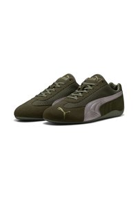Zapatos deportivos de color verde oliva con una parte superior de ante texturizado, paneles de malla y una silueta elegante. Presenta un acento de color púrpura claro y cordones.