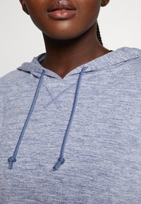 Hellblauer, strukturiertter Kapuzenpullover mit leicht meliertem Muster, ausgestattet mit einer Kordelzugkapuze und kontrastierenden blauen Schnüren.