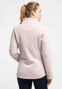 Giacca in pile rosa chiaro con colletto alto, design aderente e polsini a costine. Texture liscia, cuciture dettagliate lungo la schiena e i lati.