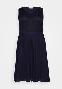 Marinblå ärmlös klänning med en spetsliv och en veckad kjol. Har en V-ringning och ett slätt satinmidjeband.