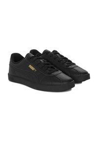 Czarne skórzane sneakersy z zaokrąglonym noskiem, płaską gumową podeszwą i tonowymi przeszyciami. Zawierają złote logo Pumy na boku.