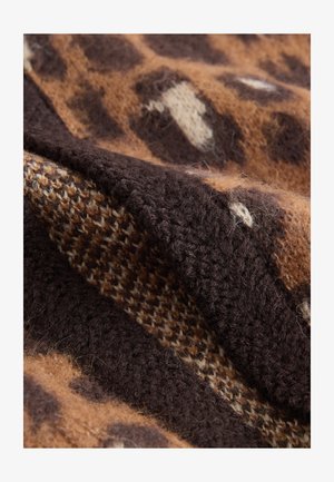 Bruin en beige geweven stof met een mix van dierenprint en rasters, met een zachte, wolachtige uitstraling en een weelderige afwerking.