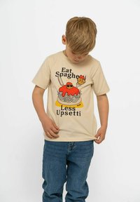 Beige Baumwoll-T-Shirt mit einem Cartoon-Nudeln-Design, das mit roter Sauce, Sonnenbrille und dem Text "Iss weniger Spaghetti, dann bist du nicht so wütend" versehen ist.