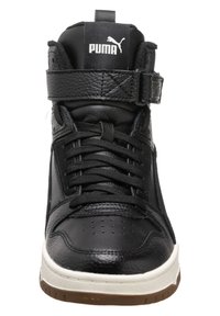 Svarta hög-top sneakers tillverkade av texturerat läder med ett kardborreband, som har snörning, perforerat tådesign och en vit mellansula.