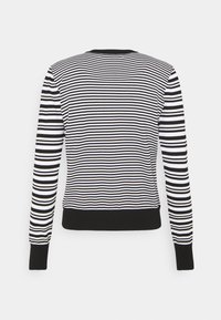 Black and white striped sweater, round neck, ribbed cuffs and hem, soft texture, with horizontal stripes of varying widths.