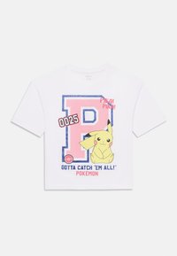 Balts īsām piedurknēm T-krekls ar lielu zilu kontūrā 'P', Pikachu grafiku un tekstu "Gotta Catch 'Em All! Pokémon" rozā un melnā krāsā.