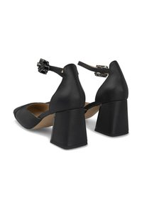 Zapatos de tacón cuadrado de cuero negro con una parte delantera texturizada, correa de tobillo ajustable con un acento decorativo y un forro interior suave.