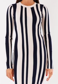 Abito a maniche lunghe con strisce verticali blu navy e crema, texture a coste, scollatura rotonda e silhouette aderente con spacchi laterali.