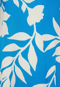 Tessuto blu con un grande motivo botanico bianco composto da foglie e fiori, caratterizzato da una trama liscia e un vivace contrasto di colori.