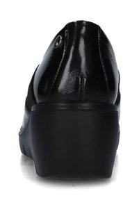 Scarpa in pelle verniciata nera con punta rotonda, tacco basso e superficie liscia. Presenta un piccolo dettaglio decorativo in metallo vicino al tallone.