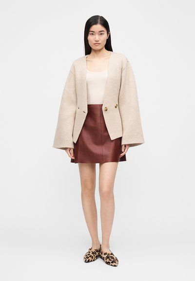 Bordinė, permatoma, vilnos mišinys megzta kardiganas su plačiomis rankovėmis, derinamas su bordo odine mini sijonu ir leopardiniu raštu bateliais.