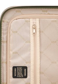 Groene kofferinterieur met beige voering met monogram, gaaszak, beige rits en een zwart zorginstructietag.