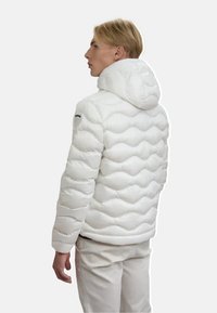 Giacca a vento bianca con un design trapuntato testurizzato e cappuccio. Presenta un logo sulla spalla sinistra e una silhouette aderente.