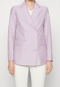 Dwurzędowa marynarka w jasnofioletowym materiale z klapami, z czterema guzikami z przodu, dwiema kieszeniami i gładką teksturą.