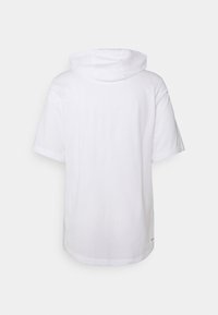 Sudadera blanca de manga corta vista desde la parte de atrás, que presenta un corte holgado y una capucha sin cordones visibles ni logotipos.
