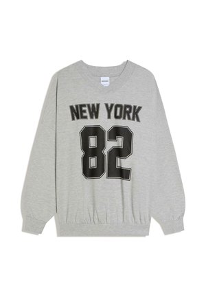 Jasnoszara bluza z dekoltem w serek, z czarnym napisem "NEW YORK" nad dużą liczbą "82" na przodzie.