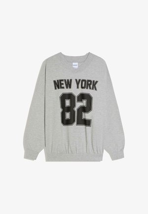 Jasnoszara bluza z dekoltem w serek, z czarnym napisem "NEW YORK" nad dużą liczbą "82" na przodzie.