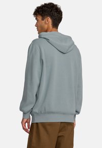 Helles blaues Kapuzensweatshirt mit lockerer Passform, gerippten Bündchen und Saum sowie weichem, strukturiertem Stoff. Verstellbarer Kordelzug an der Kapuze.