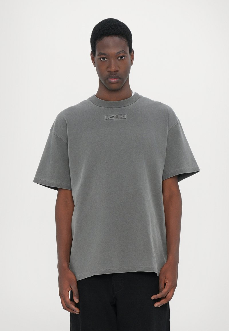 T-shirt oversize gris en coton, avec des manches courtes, un col rond et un petit logo brodé sur la poitrine.