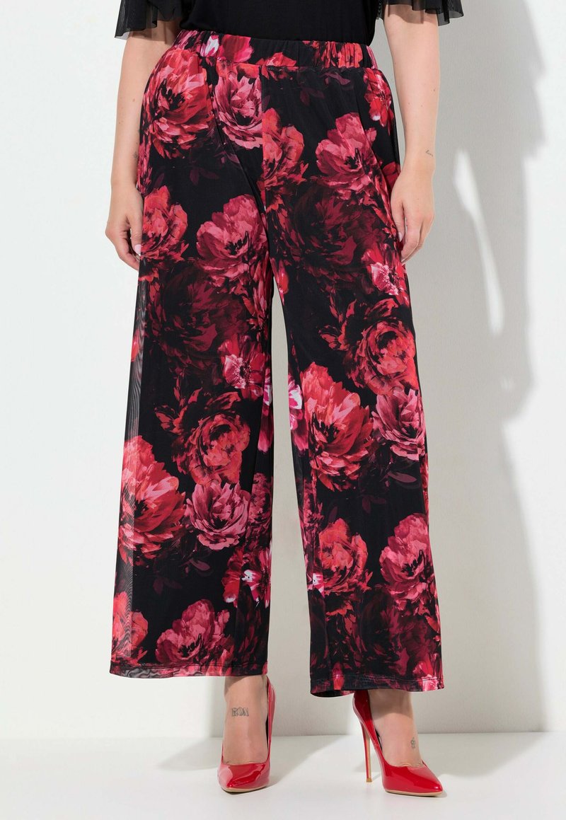 Květinové široké kalhoty v černé barvě s velkými červenými a růžovými květinovými vzory. Lehké, s elastickým pasem, doplněné červenými vysokými podpatky.