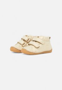 Beige peuterschoenen met twee klittenbandsluitingen en bruine rubberen zolen, naast elkaar weergegeven op een witte achtergrond.