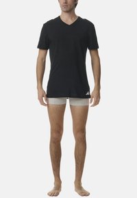 Svart v-ringad t-shirt och ljusgrå boxertrosor. T-shirten har en slät yta med korta ärmar; trosorna är åtsittande och enkla.