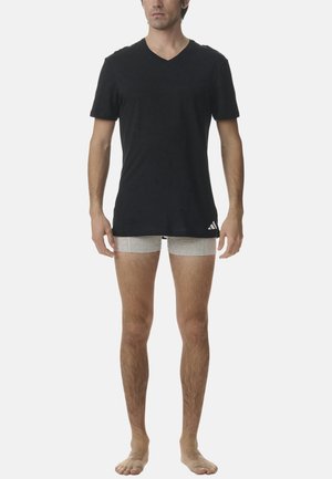 Sort v-hals t-shirt og lysegrå boxershorts. T-shirten har en glat tekstur med korte ærmer; boxershortsene er tætsiddende og ensfarvede.