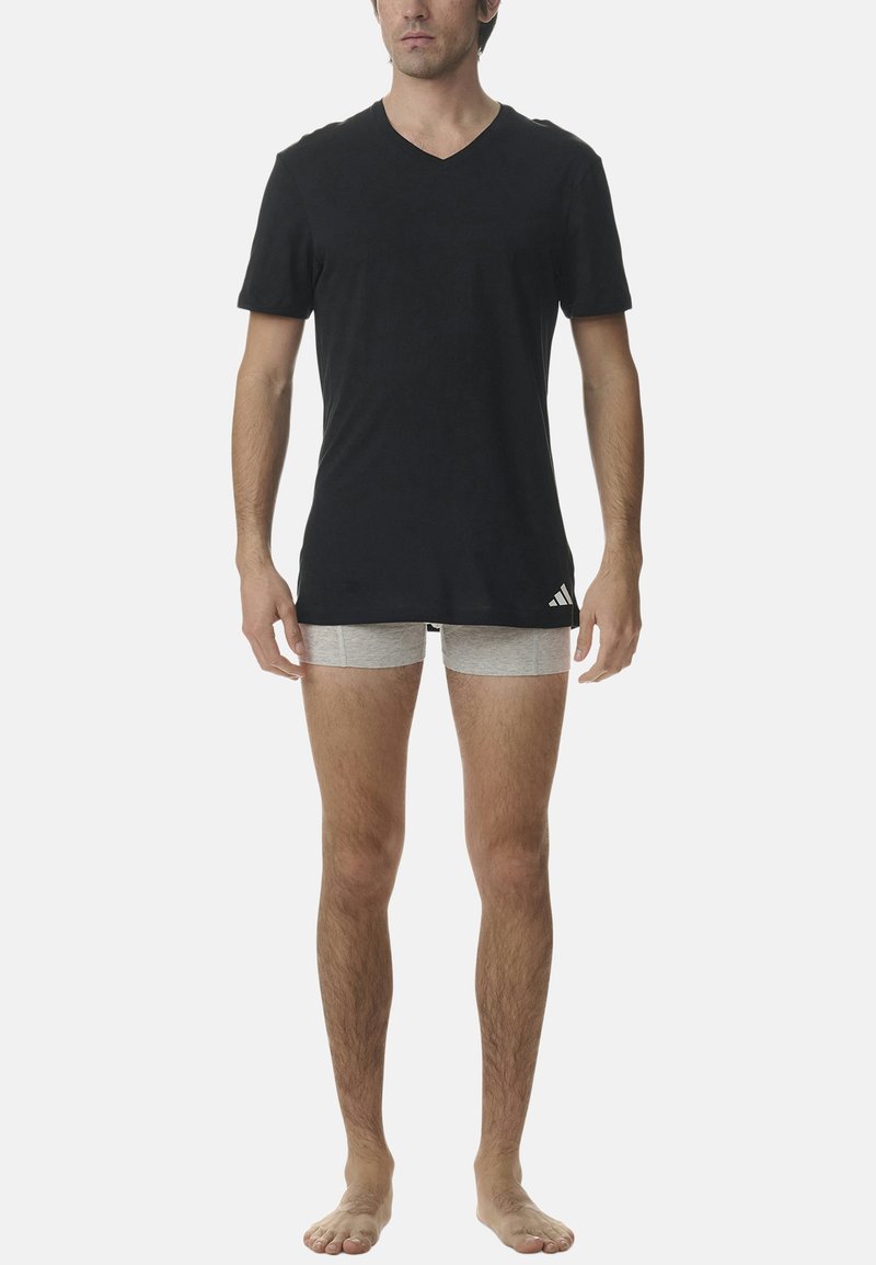 Svart v-ringad t-shirt och ljusgrå boxertrosor. T-shirten har en slät yta med korta ärmar; trosorna är åtsittande och enkla.