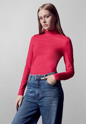 Rode longsleeve turtleneck top gecombineerd met hoog-waardig blauwe denim jeans. Glad materiaal met een aansluitende pasvorm. Klassiek ontwerp met vijf zakken.