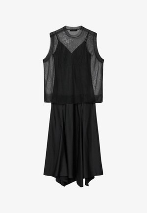 Musta hihaton mekko, jossa läpikuultava verkkomainen yläosa ja virtaviivainen epäsymmetrinen helma, ripustettuna valkoista taustaa vasten.