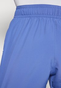 Hellblaue Sportshorts mit elastischem Bund, glatter Textur und Seitennähten. Sie haben einen lockeren Schnitt und bestehen aus leichtem Material.