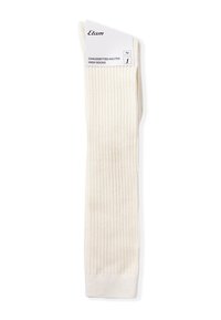 Altos calcetines de suave tela de crema acanalada. Presentan una textura lisa, con un puño doblado y una etiqueta adjunta en la parte superior.