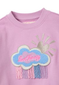 Sudadera de color púrpura claro con un diseño de nube multicolor, con texto bordado "Love Therapy" y detalles de flecos texturizados.