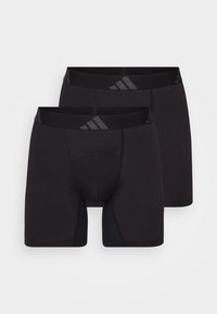Boxers atléticos pretos feitos de tecido elástico. Apresentam um design sem costuras e uma faixa elástica larga com um logótipo, proporcionando conforto e suporte.