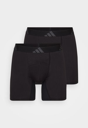 Black athletic boxers made of stretchy fabric. Features a seamless design and a wide elastic waistband with a logo, providing comfort and support.