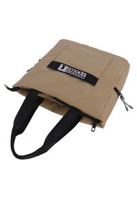 Bolso tote acolchado beige con asas negras y logo. Presenta cierre de cremallera y un bolsillo exterior. El material parece duradero y texturado.