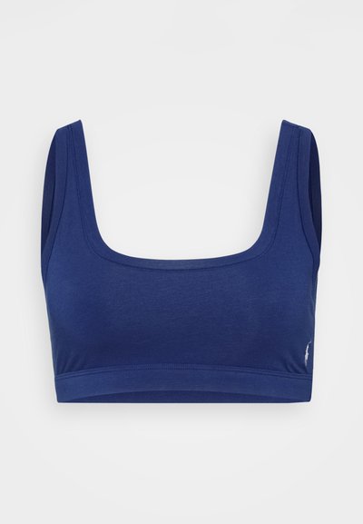 Μπλέ σκούρο cropped top με φαρδιές τιράντες και τετράγωνη λαιμόκοψη. Κατασκευασμένο από απαλή ύφανση με εφαρμοστή, χωρίς ραφές σχεδίαση. Λογότυπο στην κάτω πλευρά.