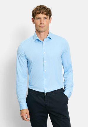 Light blue button-up shirt with long sleeves, smooth texture, and a collar. Paired with dark trousers, displayed against a plain background.
