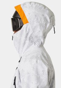 Veste de neige avec un motif camouflage blanc, accent à capuche orange, cordons de serrage réglables et col haut. Présente un design professionnel pour les temps froids.