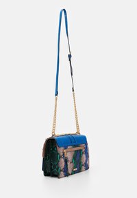 Wielokolorowa torebka z niebieską teksturowaną górą, zielono-różowymi bokami w wężowy wzór, złotym łańcuszkiem jako paskiem i przednią kieszenią na suwak.