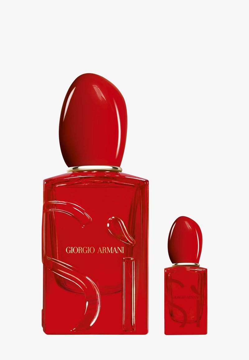 Due flaconi di profumo rossi con tappi arrotondati, uno grande e uno piccolo, entrambi etichettati Giorgio Armani su uno sfondo semplice.