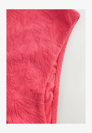 Vaaleanpunainen kangas, jossa on kohotettuja kukkakuvioita ja teksturoituja yksityiskohtia, joissa on sileät reunat ja pehmeä, kevyt rakenne.