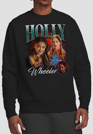 Black sweatshirt featuring three portraits of a girl with red hair styled in pigtails, with the text "Holly Wheeler."