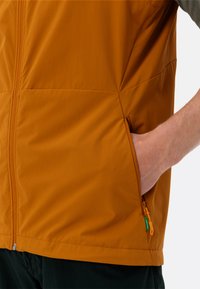 Leichte, orange Jacke mit einem Frontreißverschluss, seitlicher Tasche mit kontrastierendem Reißverschluss und glattem Stoff.